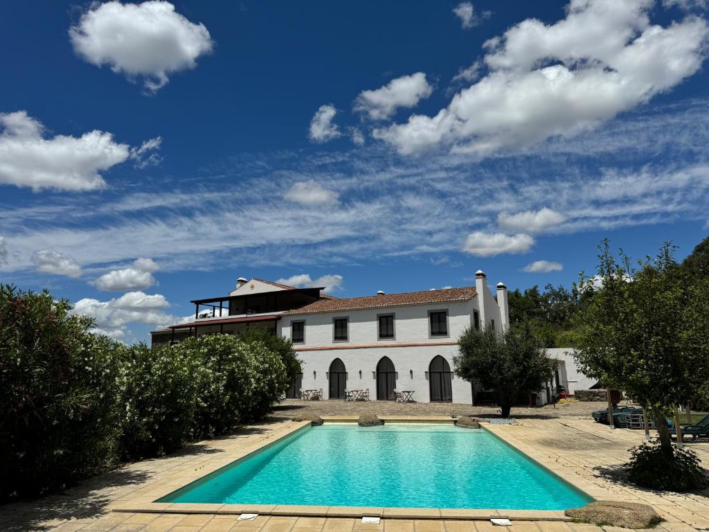a villa with a swimming pool in front of a building at Convento da Provença in Portalegre