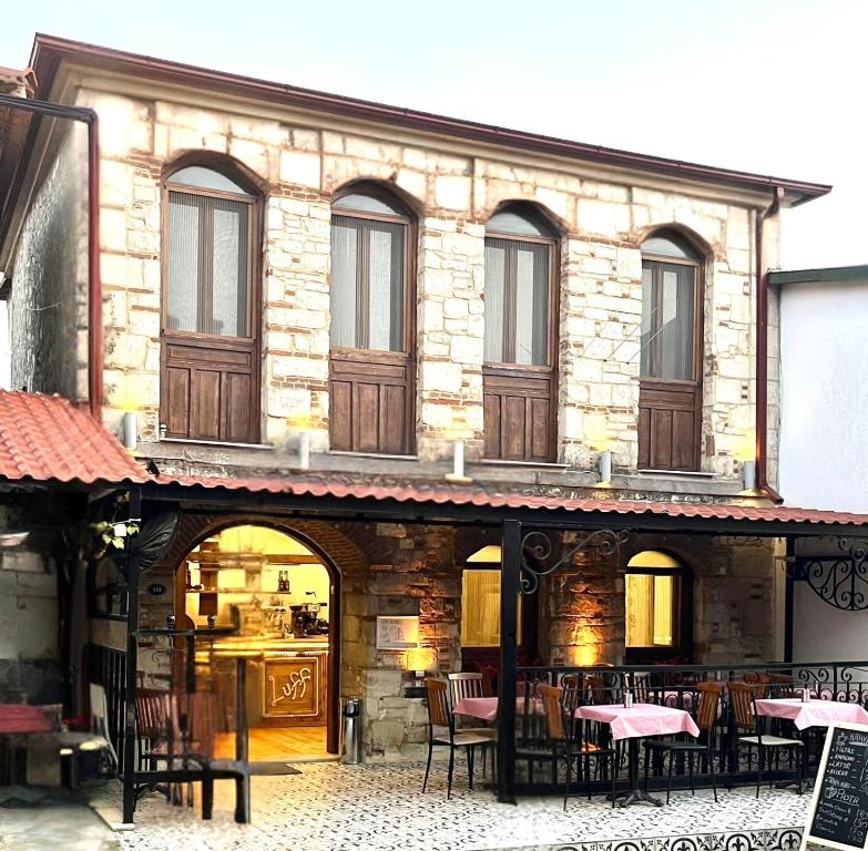 a restaurant with tables and chairs in front of a building at Bademli Ancanoz Hotel in Dikili