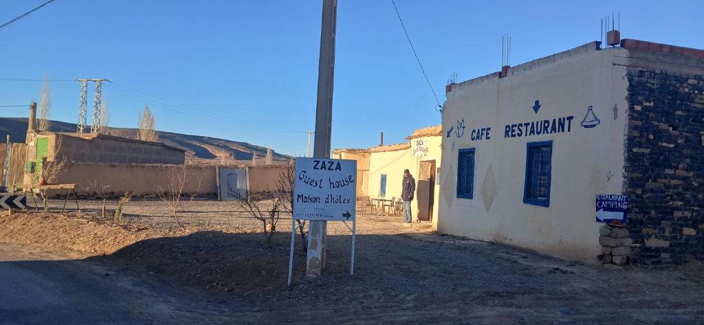 a sign in the dirt next to a building at ZAZA Guest house in Agoudal