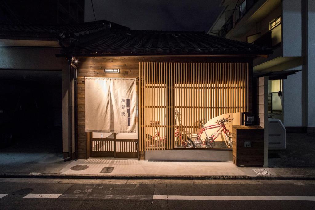 a gate to a building with a chair behind it at Nijojo Taiken Inn in Kyoto
