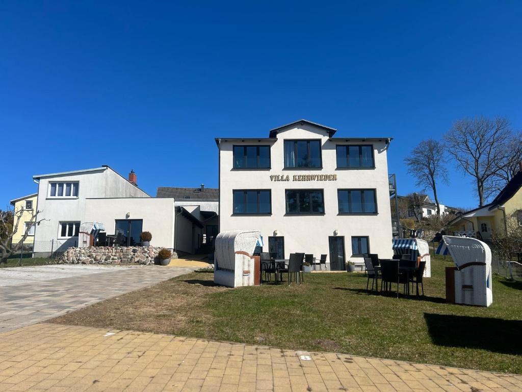 a white building with chairs in front of it at Villa Kehrwieder Göhren in Göhren