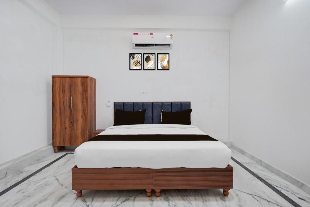 a bedroom with a large bed with a wooden dresser at Hotel O The Skyrise Lucknow Hotel in Lucknow