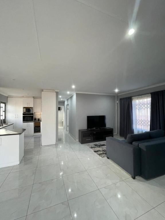a large living room with a couch and a kitchen at Villa Amari in Aliwal North