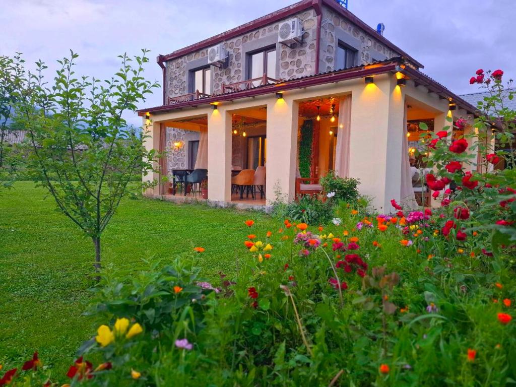 a house with a field of flowers in front of it at Old Tatev Guesthouse in Tatʼev