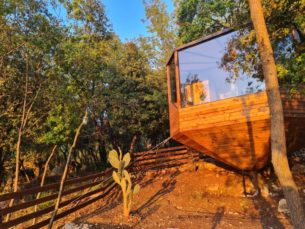 a tree house with a large window on the side of it at MONKEY MANSION - Luxury Treehouse - Private Escape with outdoor hot Tub in Abū Mīzān