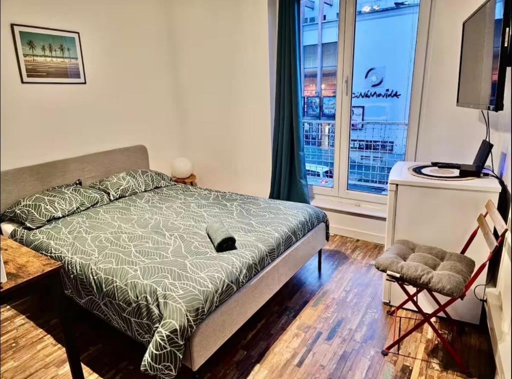a bedroom with a bed and a large window at Bogota in Laon