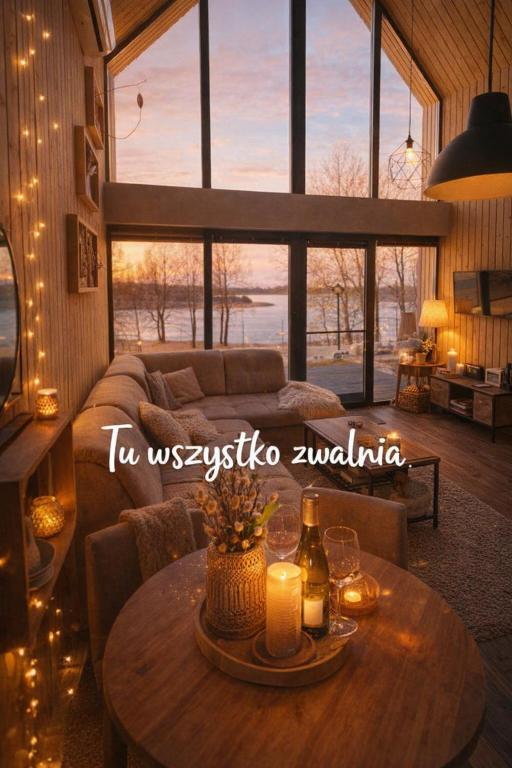a living room with a couch and a table with candles at Hytte Na Wyspie -,,Roztoczańskie Morze'' in Kulików