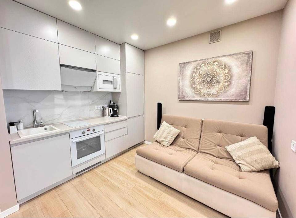a living room with a couch and a kitchen at Ривер люкс Днепр in Dnipro