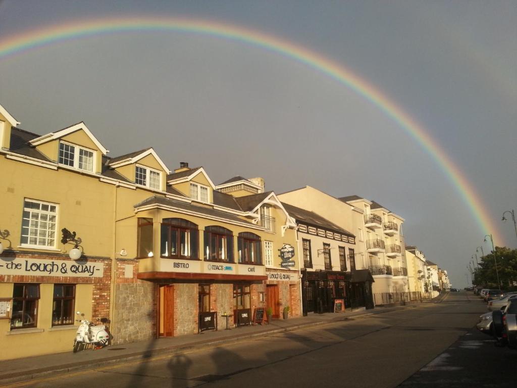 a rainbow in the sky over a city street at The Lough and Quay in Warrenpoint