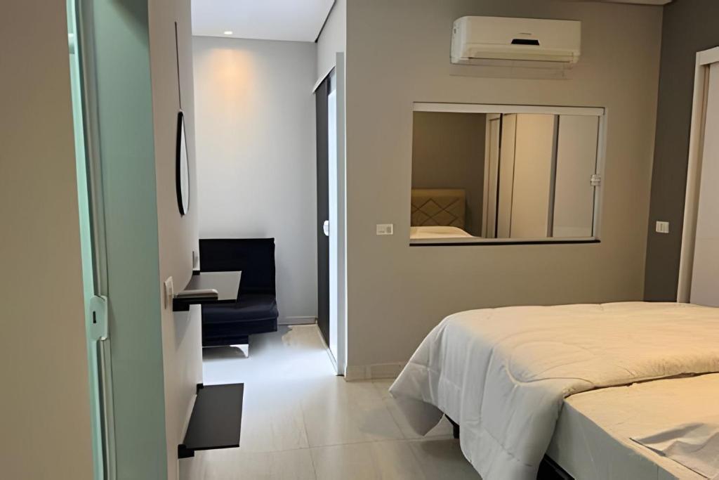 a small bedroom with a bed and a mirror at Hospedaria Santo Descanso (Edícula) in Uberlândia