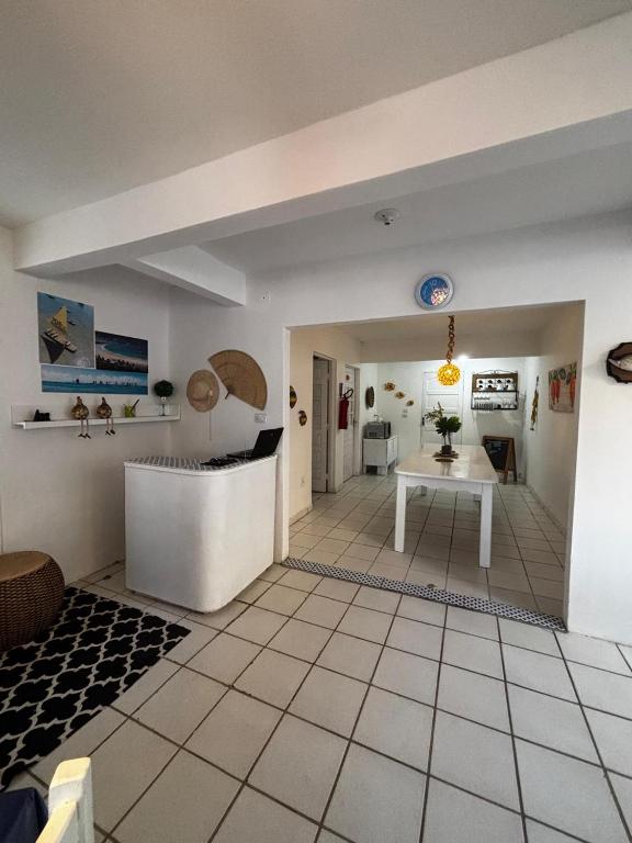 a living room with a white floor and a table at Suítes Marrakesh in Porto De Galinhas