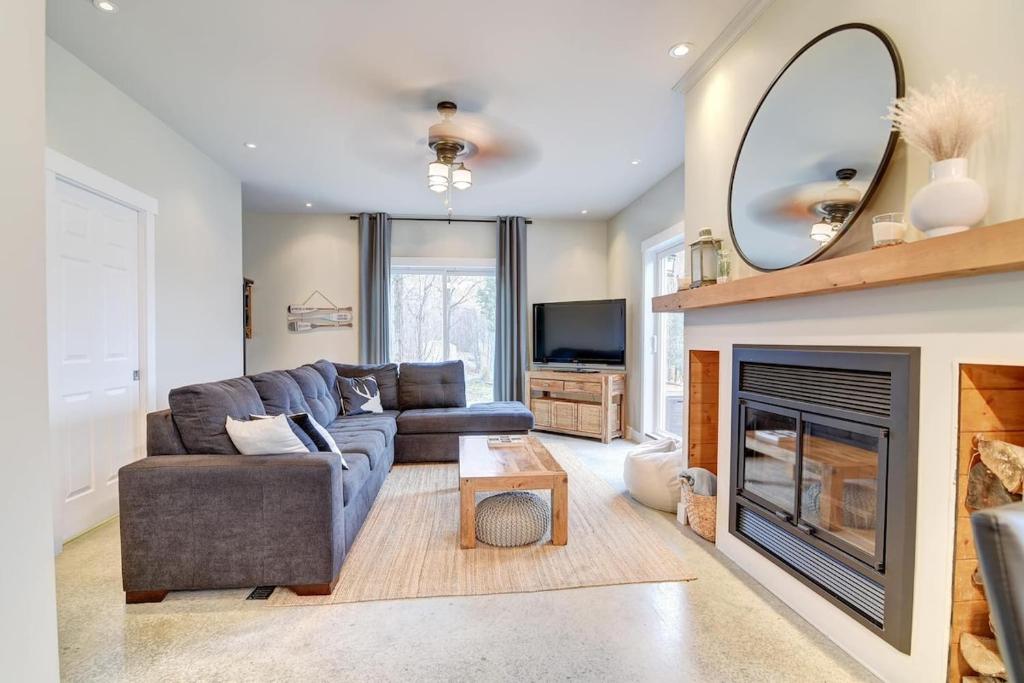 a living room with a couch and a fireplace at Lake Joseph Retreat -Waterfront and Hot tub in Saint-Pierre-Baptiste