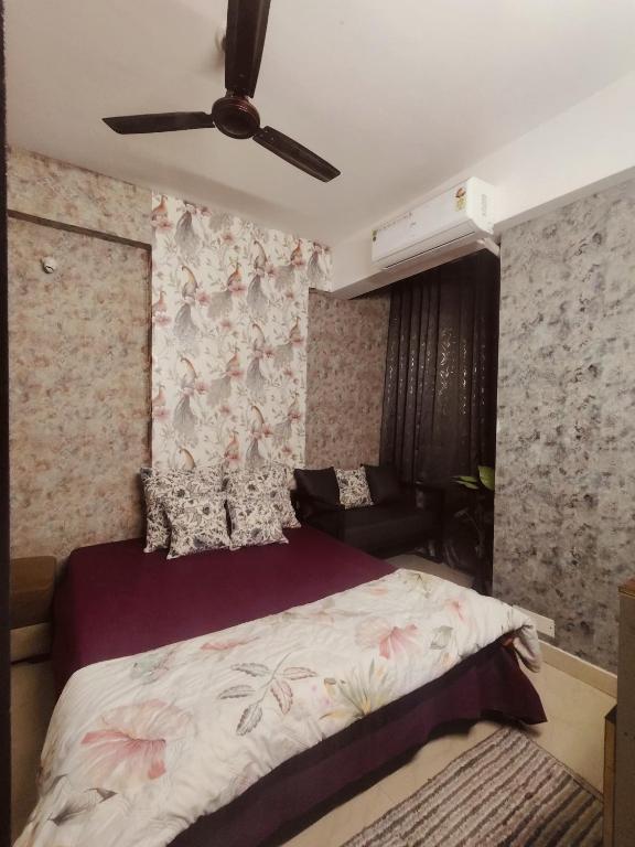 a bedroom with a bed and a ceiling fan at StudeXO in Ghaziabad