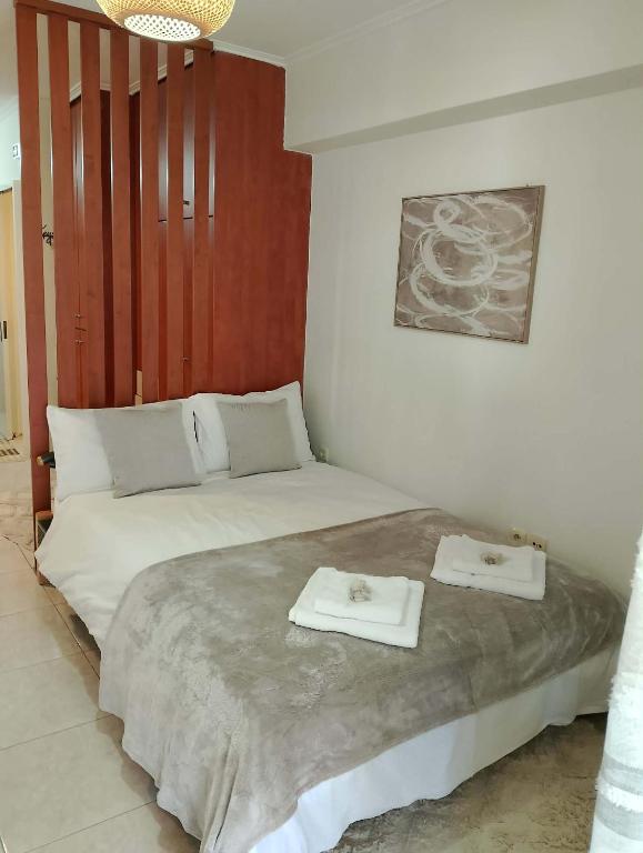 a bedroom with a bed with two towels on it at ΚΝΗΜΙΣ Apartment in Agios Konstantinos