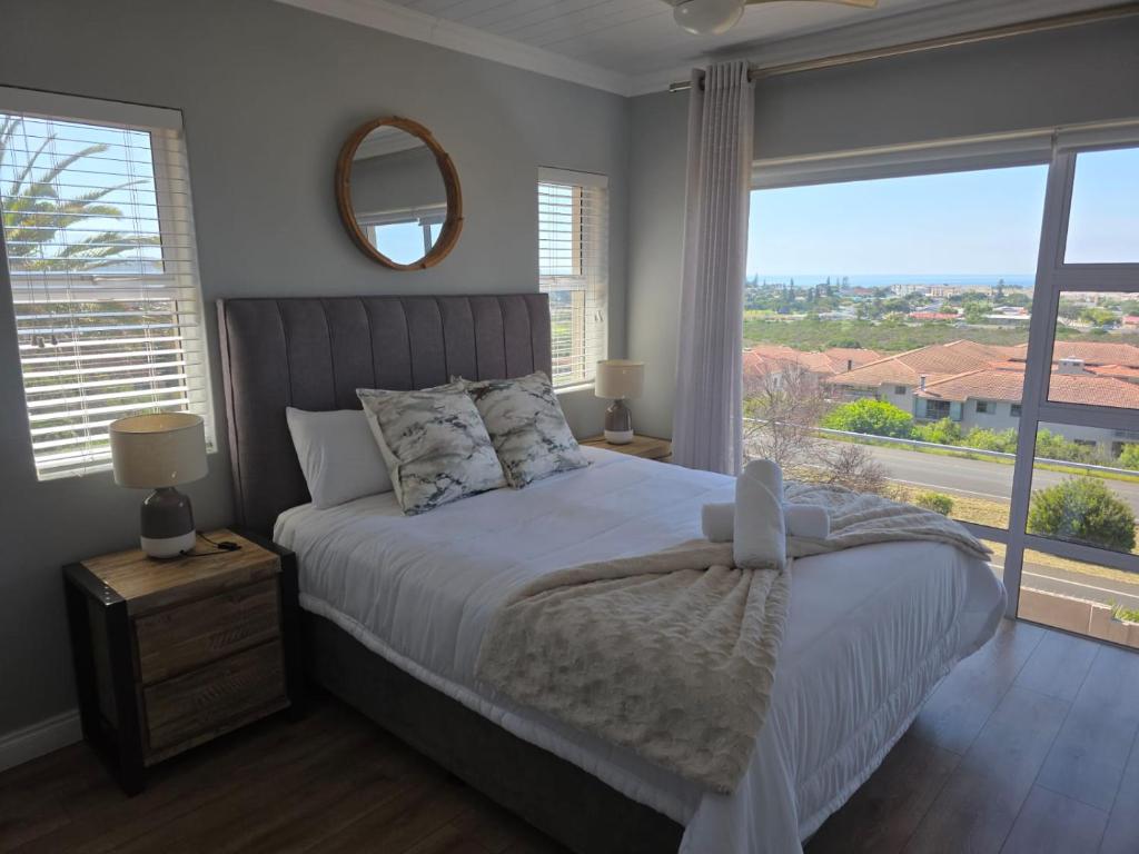a bedroom with a bed and a large window at Heuwels Haven in Mossel Bay