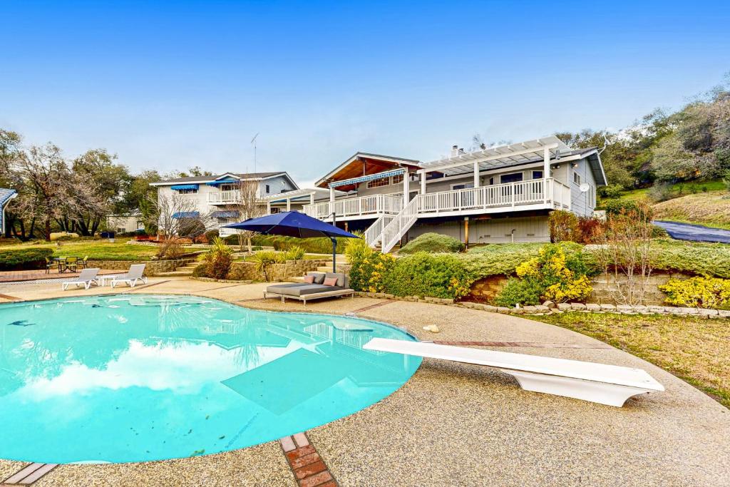 a house with a swimming pool in front of a house at 'Whispering Oaks Estate' w/ Pool & View in Murphys in Vallecito