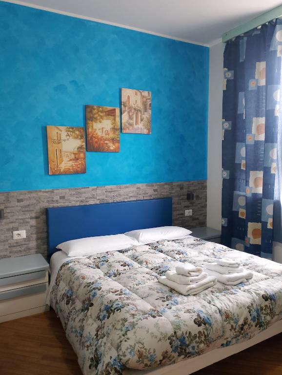 a bedroom with a bed with a blue wall at Affittacamere Le Ginestre in Colleferro