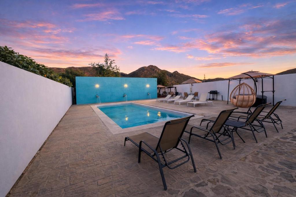 a patio with a table and chairs and a pool at HOTEL LARIMAR - Valle de Guadalupe in Dinuva