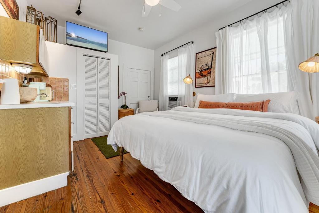 a white bedroom with a large bed and a window at NIGHTCAP @ Speakeasy Inn Key West! in Key West