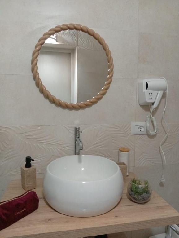 a bathroom with a white sink and a mirror at Le Suite di Antonella in Taranto