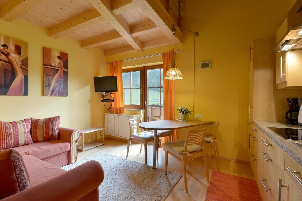 kuchnia i salon ze stołem i kanapą w obiekcie Appartement Haus Schröder w mieście Söll