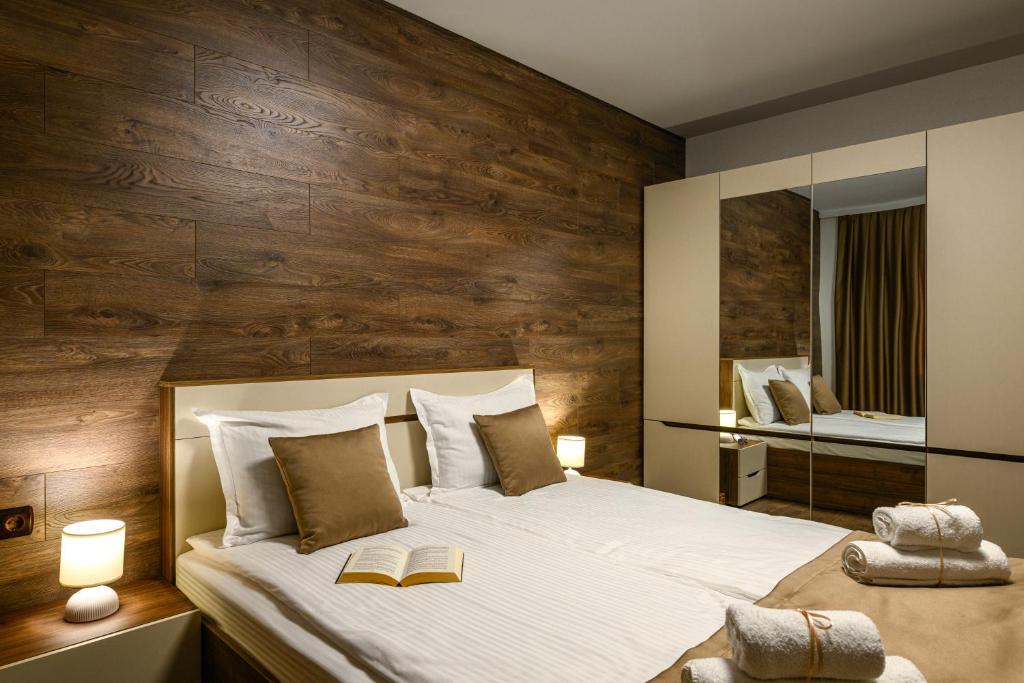 a bedroom with a large bed with a wooden wall at Libertè suites Velingrad in Velingrad