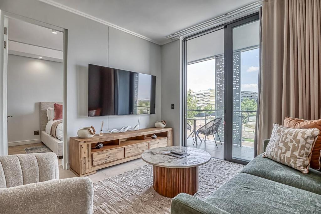 a living room with a tv and a couch and a table at Caica Executives at Ellipse 4108 in Midrand