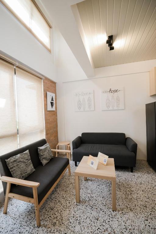 a living room with two black couches and a table at Casita Benito Loft D in Sangley Point Naval Station