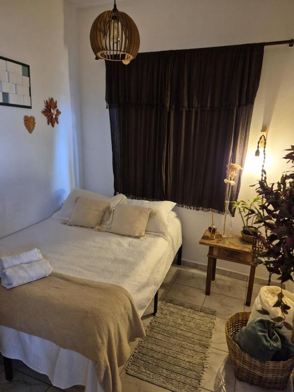 a bedroom with a bed and a large window at Mini Casa Tiradentes 2 in Tiradentes