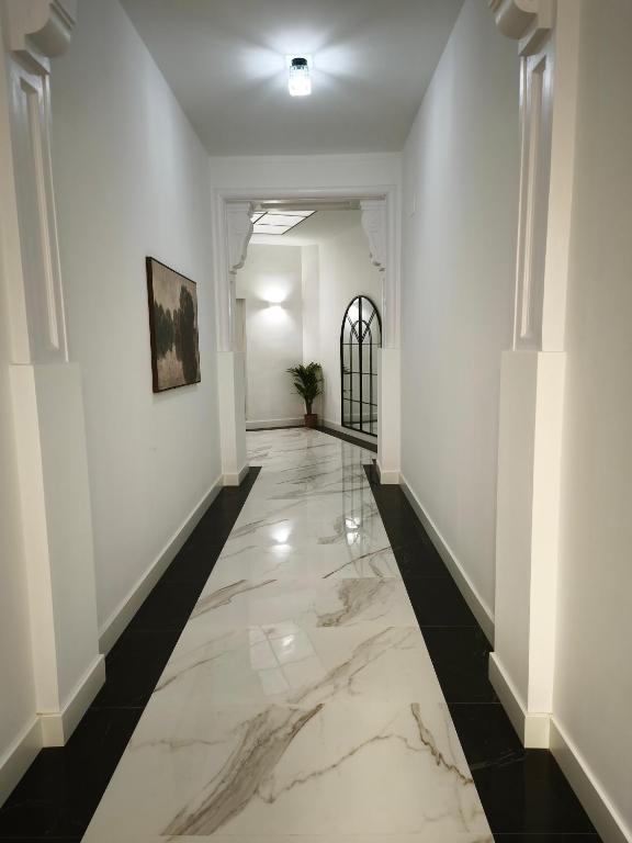 a hallway with white walls and a marble floor at Apartamentos Turísticos Penadés in Tomelloso