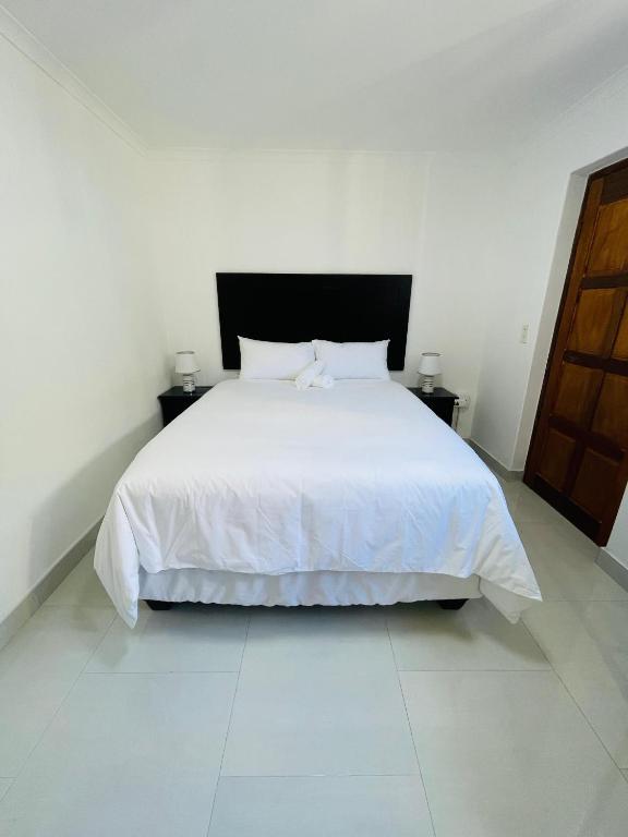 a bedroom with a white bed with two night stands at Ruka Manor B&B in Strand