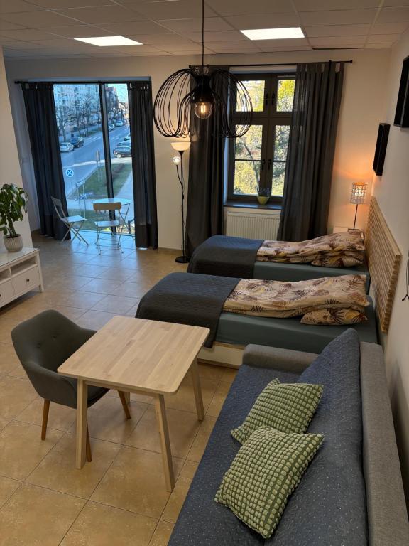 ein Wohnzimmer mit drei Betten und einem Tisch in der Unterkunft Studio Olecko in Olecko