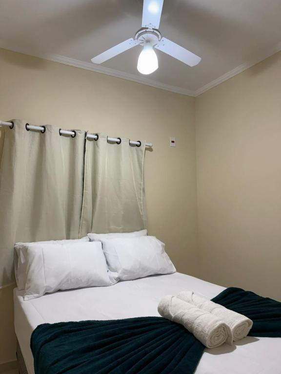 a bedroom with a bed with a ceiling fan at Hotel e Pousada Santa Helena in Potim