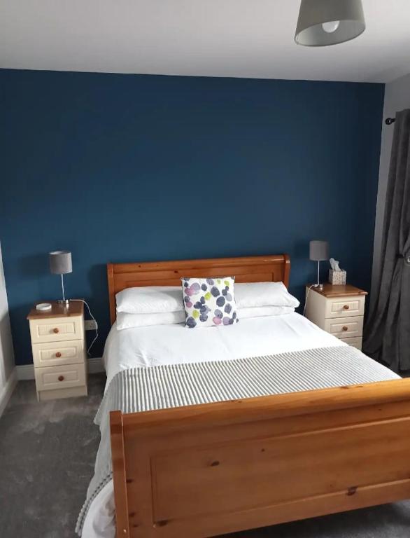 a bedroom with a wooden bed with a blue wall at Blue Haven in Upper Ballycotteen