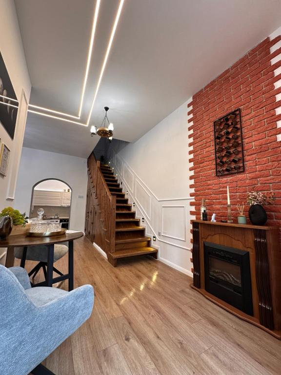 a living room with a staircase and a brick wall at Norderney Apartments in Sibiu