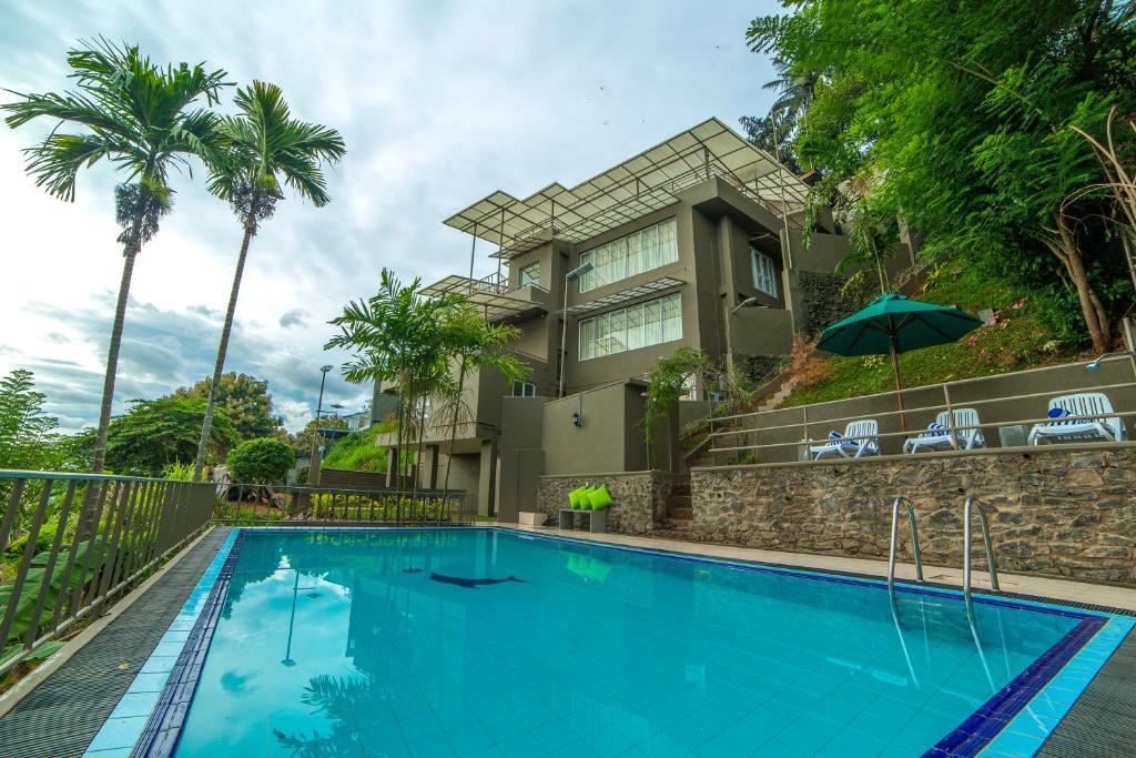 a swimming pool in front of a house at Range Kandy in Kandy