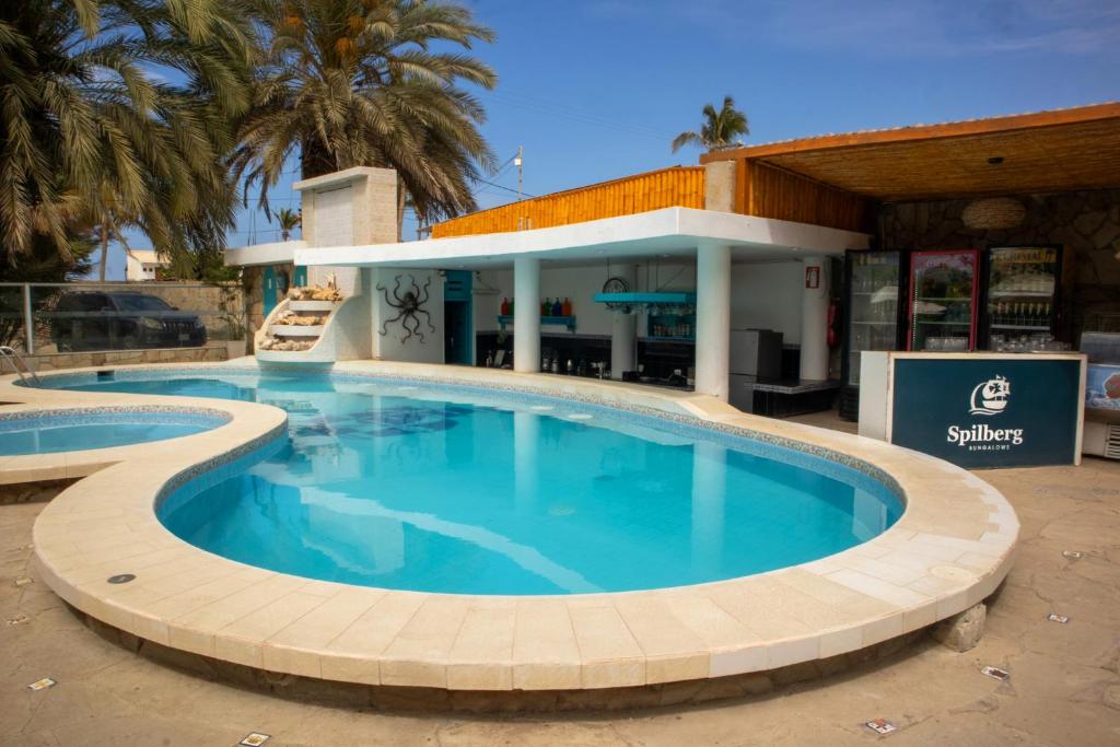 a large swimming pool in front of a building at Bungalows Spilberg in Colán