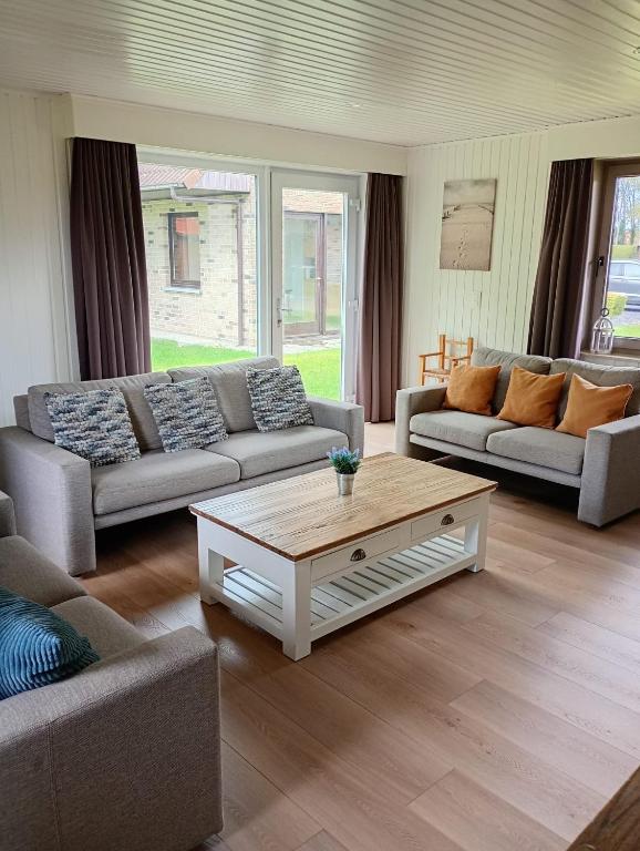 a living room with two couches and a coffee table at Family Bungalow De Strandjutter 8 people in Middelkerke