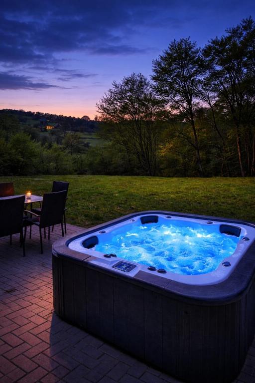 a jacuzzi tub with a table in a field at Ferienhaus Haselnuss in Schleiden