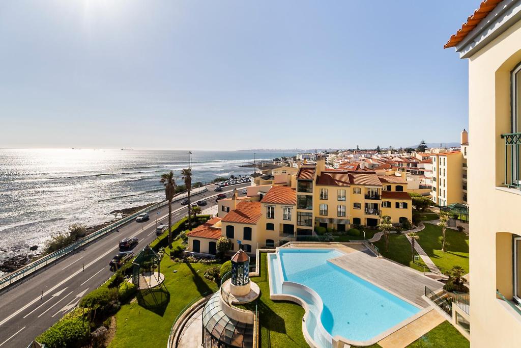 an aerial view of a resort with a swimming pool and the ocean at Cascais Lux - New Apartment in Parede