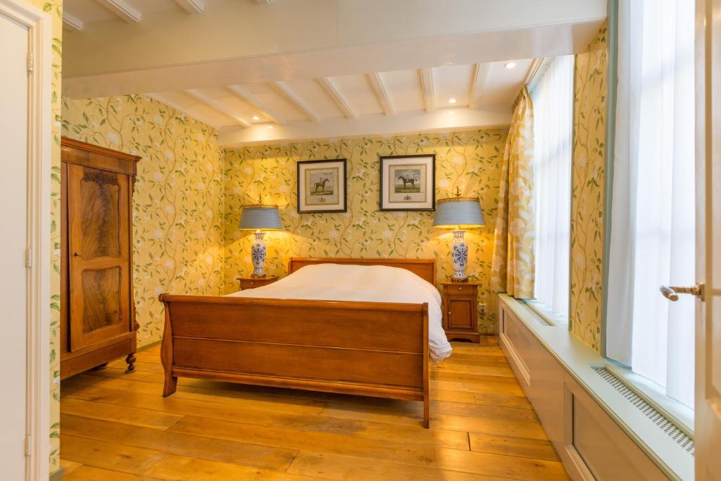 um quarto com uma cama e papel de parede amarelo em The Heritage - R.Q.C. em Haia