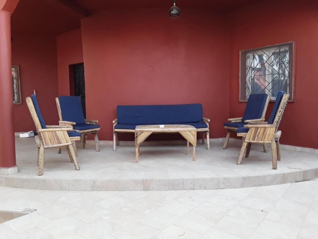 a group of chairs and a table with a blue couch at KEUR MAMY DOUSSOU à Ndangane campement in Ndangane