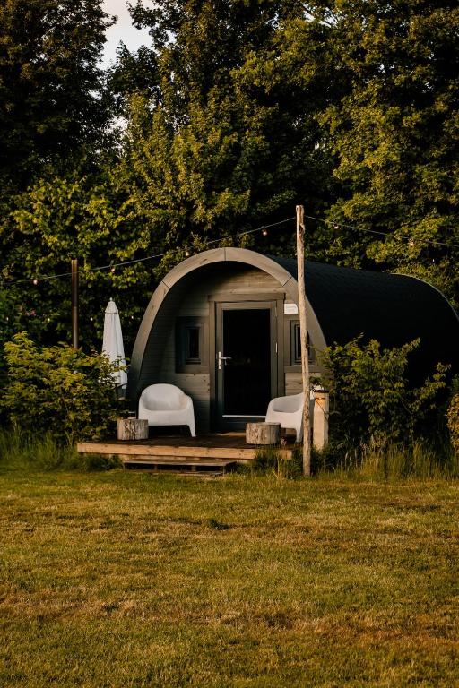 a dome tent with two chairs and a table at Glamping Pod in de natuur Eigen badkamer in Oudehornstercompagnie