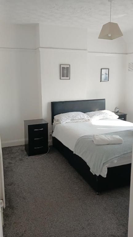 a bedroom with a large bed and a night stand at Zoran home 3 in Leicester