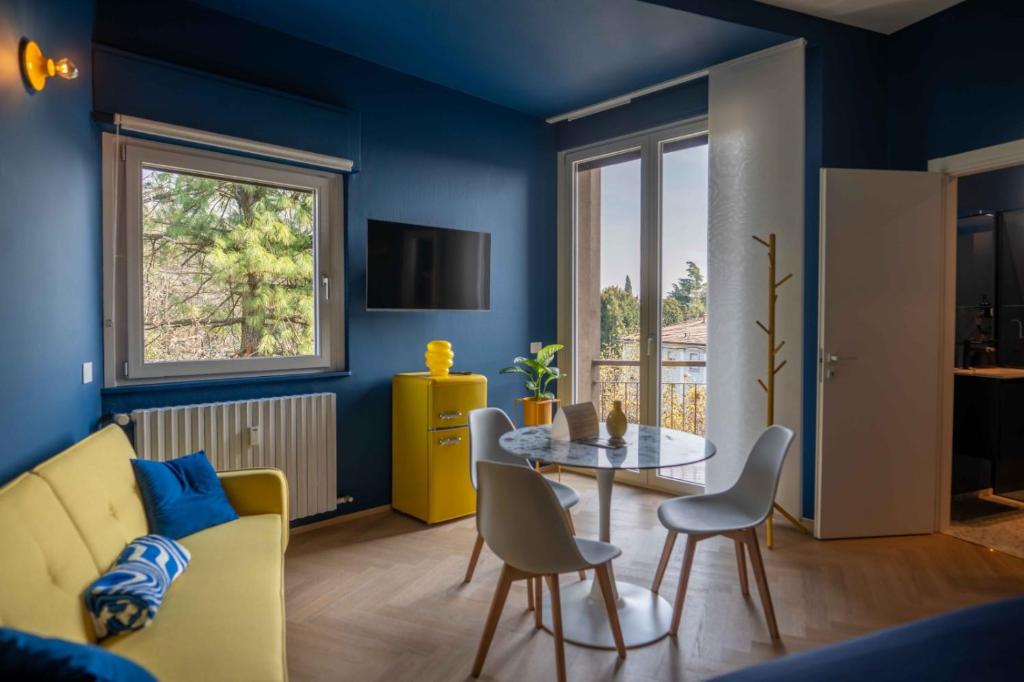 a living room with a yellow couch and a table at MR Suites Bergamo in Seriate
