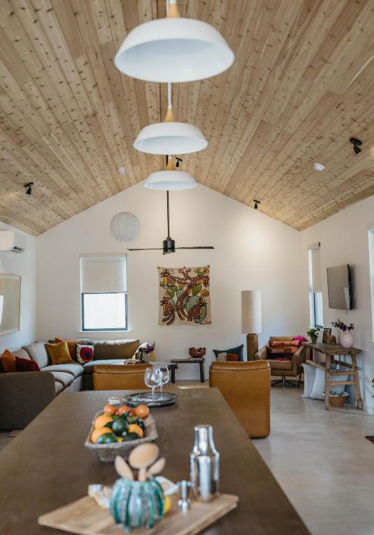 a dining room and living room with a wooden ceiling at Camp Cold Springs in Concan