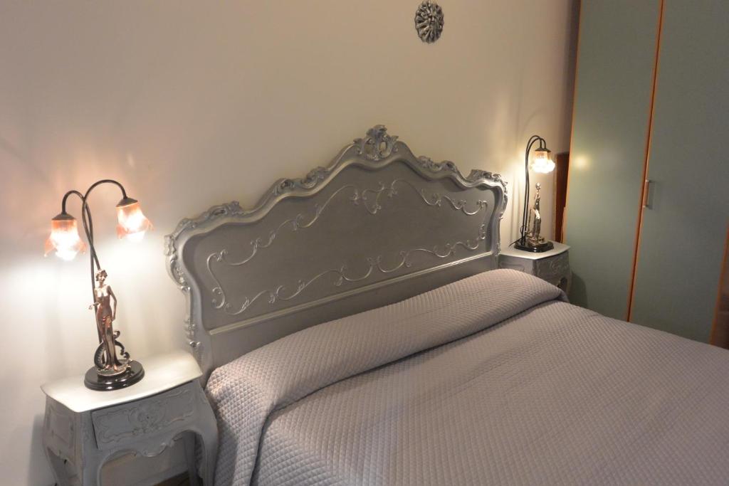 ヴェローナにあるB&B Gannaのベッドルーム1室(白いベッド1台、テーブルにランプ2つ付)