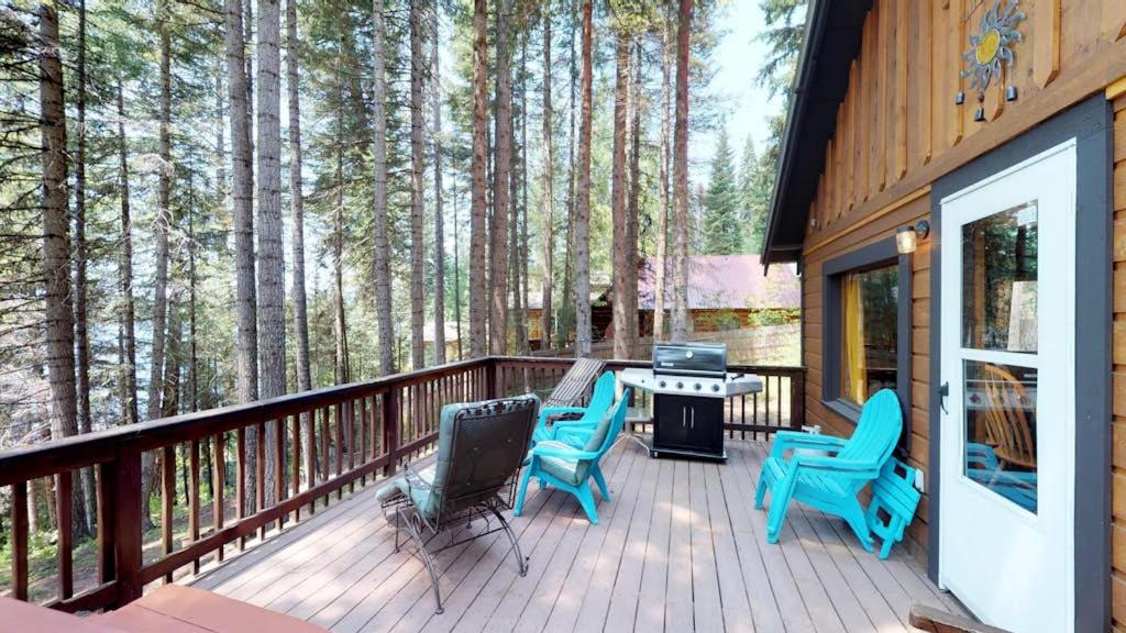a deck with chairs and a table with a grill at Beth's Lakeside Cabin in McCall