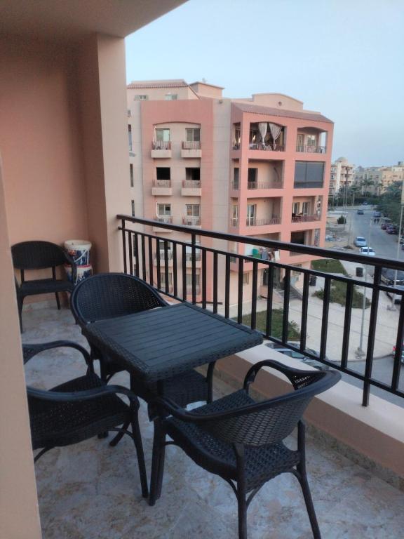 a balcony with a table and chairs on a balcony at Building 211, Gulf 2, Apartment 403 in ‘Ezbet `Abd el-Ḥamîd