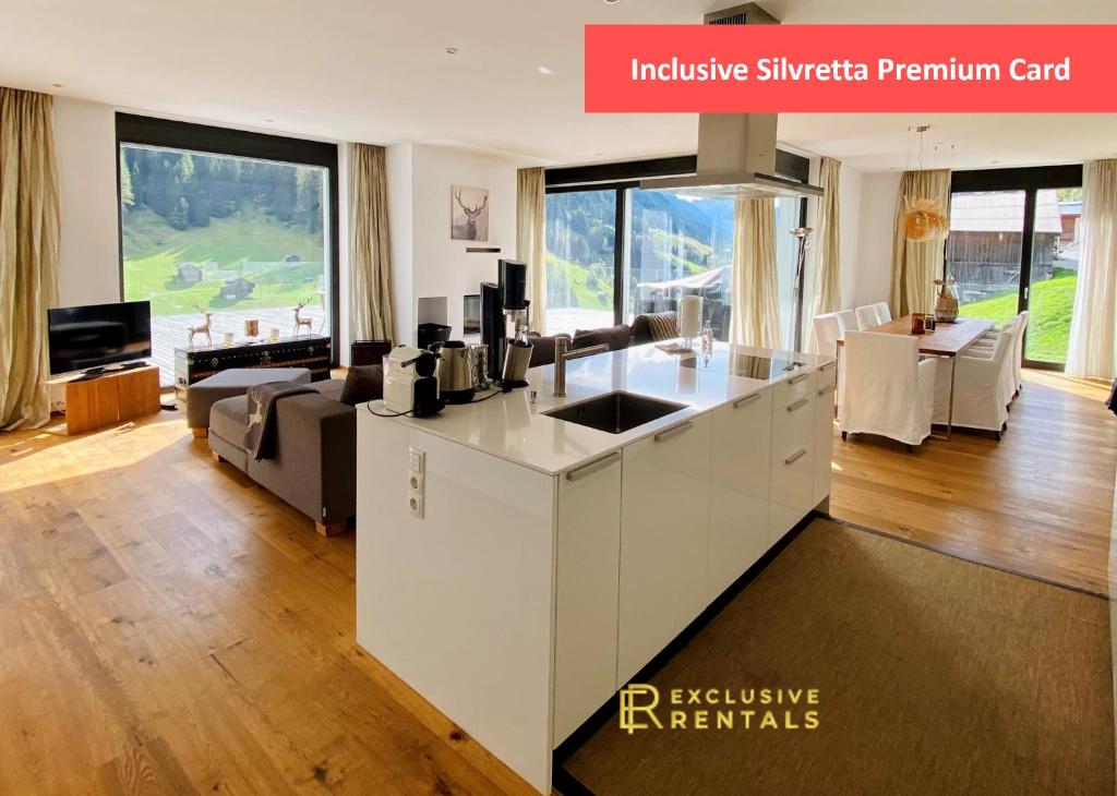 a kitchen and living room with a large window at Schooren des Alpes Luxury Penthouses & Apartments with SPA & Pools close Ischgl in Kappl
